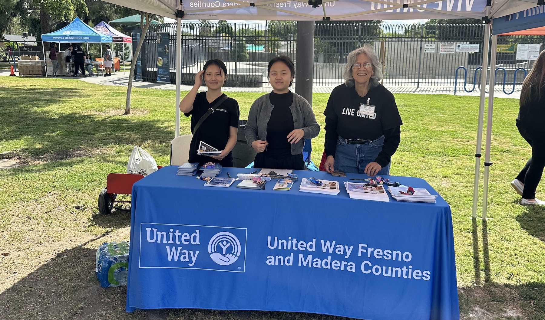 Three United Way team members staff a booth at an outreach event